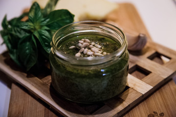 Fresh pesto with basil in glass jar.