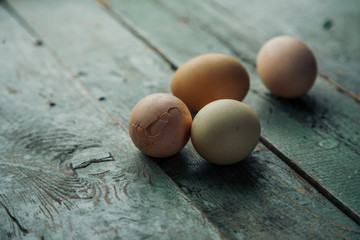 Easter farm eggs on rustic wooden table. Angle view.