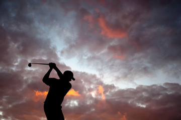 Golfer playing golf during sunset at competition event