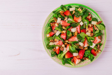 Salad with strawberry, spinach, walnuts and goat cheese