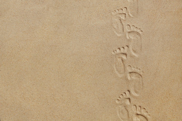 Fototapeta na wymiar Cute baby footsteps on sandy beach with space for text or desighn
