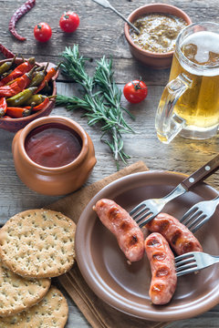 Grilled sausages with appetizers and mug of beer