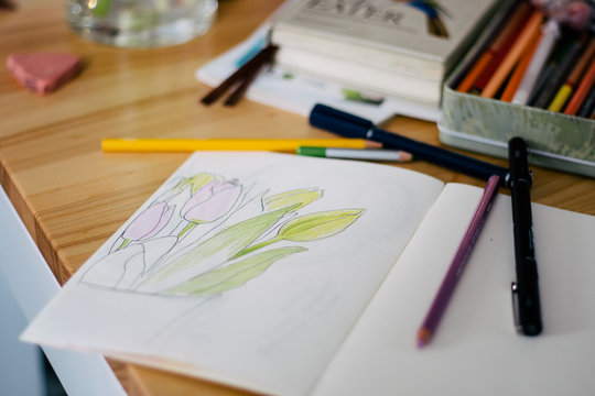 Blank white notepad with pens on wooden table