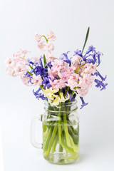 Different hyacinth flowers in glass jar