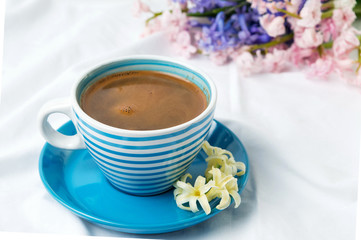 Obraz na płótnie Canvas Cup of coffee and hyacinth flowers