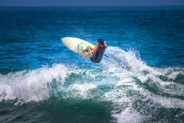 A surfer flies in the air above the wave.