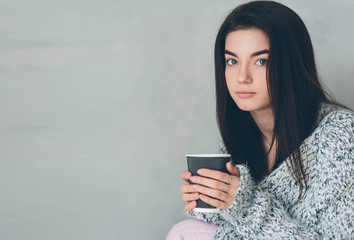 Young girl drinks delicious utensils of the coffe and thinks about plans for the day