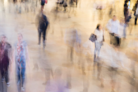 Fast Moving Crowd Of Commuters At Grand Central Station In New York. Motion Blur Of Figures Headed To Their Jobs. Working Life In The City.