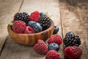 Blueberries and raspberries bowl on wooden table