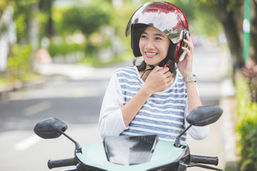 Fototapeta premium woman put her helmet on before riding a motorbike