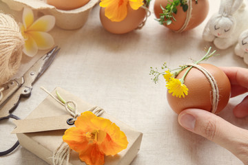 Hipster eco craft Easter eggs with flowers and herbs on linen copy space  background