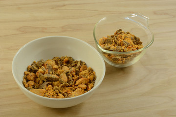 Bowl and measuring cup of crushed candy bar bits for cooking of food topping