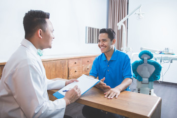 dentist talking to his patient at dental care clinic