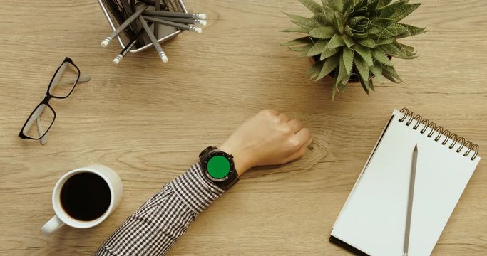 Business woman using her smart watch with green screen. Scrolling and tapping images. Female hands top view. Office desk background. Slow motion. red epic. Businesswoman