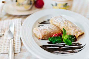 Pancakes with chocolate, fresh strawberry and mint