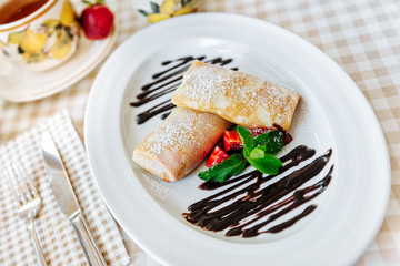 Pancakes with chocolate, fresh strawberry and mint