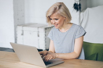 Smiling young woman working on laptop