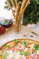 Pizza with glass of wine, on served table