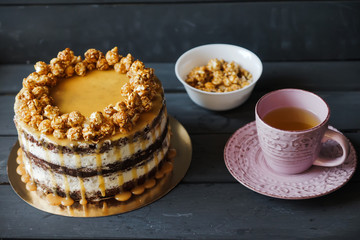 Delicious cake with caramel popcorn and caramel sauce
