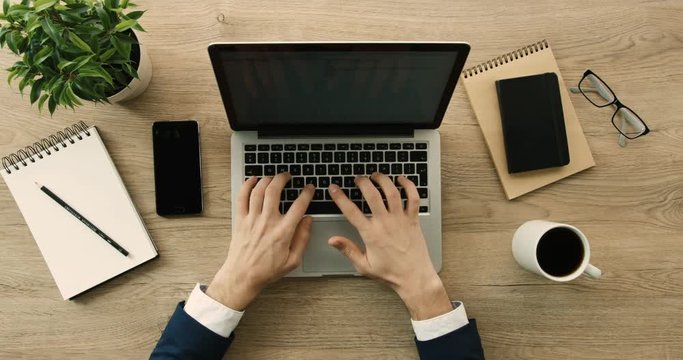 Business man working and writing in laptop on office desk background. Hands top view. Slow motion. red epic