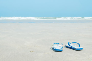 Summer holiday concept. Pair of sandals on the beach.