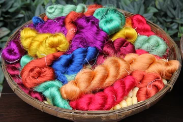 Zelfklevend Fotobehang Travel to Bangkok, Thailand. Colorful threads of Thai silk in a basket closeup for background. © Nadezhda Zaitceva