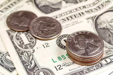 Coins on the background of US dollars banknotes. Focus in the foreground