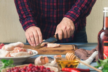 Preparation healthy food. Man cooking chicken wings with cranberry sauce