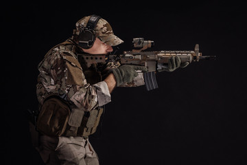 Portrait soldier or private military contractor holding sniper rifle. war, army, weapon, technology and people concept. Image on a black background.