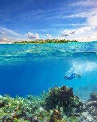 Fototapeta na wymiar Young woman snorkeling and exploring corals