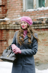 Portrait of a girl in a gray coat and pink beret in the courtyard of an old house / The picture was taken in Russia, in the city of Orenburg, on Kobozev Street.