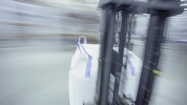 Timelapse or a speeded up video of a fork lift working in a logistics centre warehouse. Lifting goods and crates to shelf
