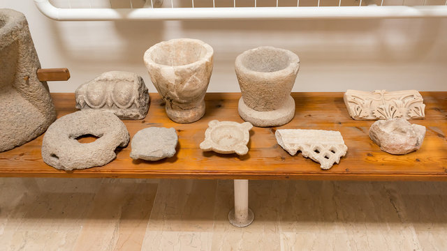 Antique Greek clay pots and stucco moulding fragments on desk. Dion, Pieria, Greece.
