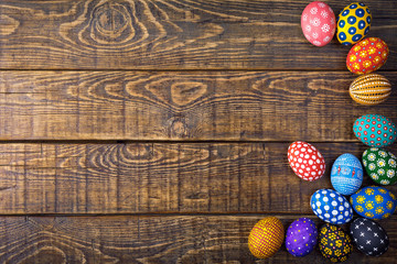 Colorful easter eggs on wooden background with space