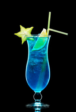 Blue lagoon cocktail with liqueur and vodka with ice cubes and slices of lime