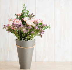 Spring bouquet in a round box on a wooden background. Copyspace