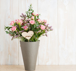 Spring bouquet in a round box on a wooden background. Copyspace