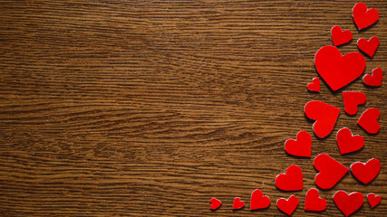 Hearts cut out of paper on a wooden background. Place for text