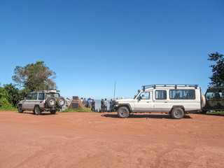 Tourists stand behind safari cars and look at huge Ngorongoro caldera. Tanzania, Africa. 
