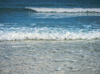 Closeup view of soft sea wave of blue ocean approaching to the beach