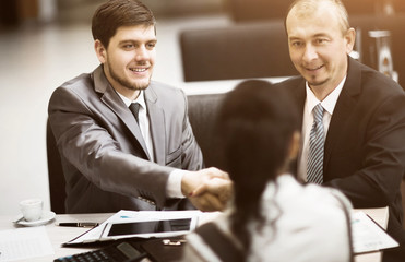 Business people shaking hands, finishing up a meeting, in the office