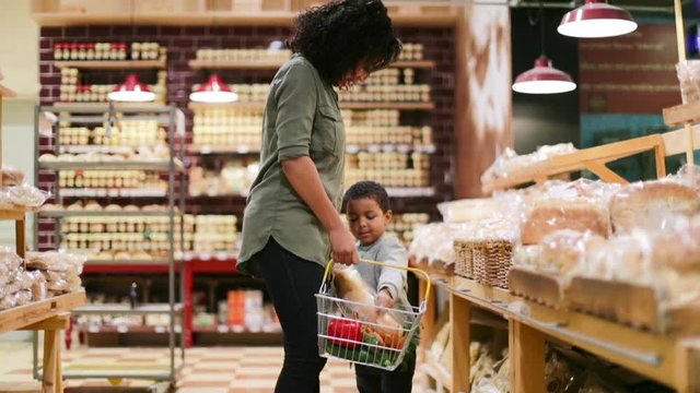 Mother and son buying bread in grocery store