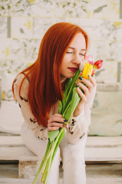 red-haired girl hollding a bouquet of tulips