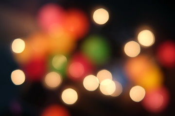 Photo of bokeh lights on black background. City night lights. Filtered color. Bokeh effect golden light texture on black background