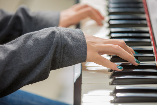 Closeup woman's hand playing piano.