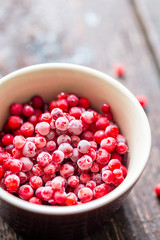 Frozen Cranberry in Bowl on Wooden Background