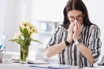 Concentrated woman blowing her nose