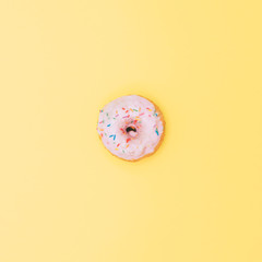 one isolated donut on yellow. delicious fast food.