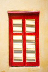 Red-yellow old window with blinds