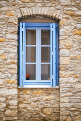 Fototapeta na wymiar Light blue old window on a stone wall
